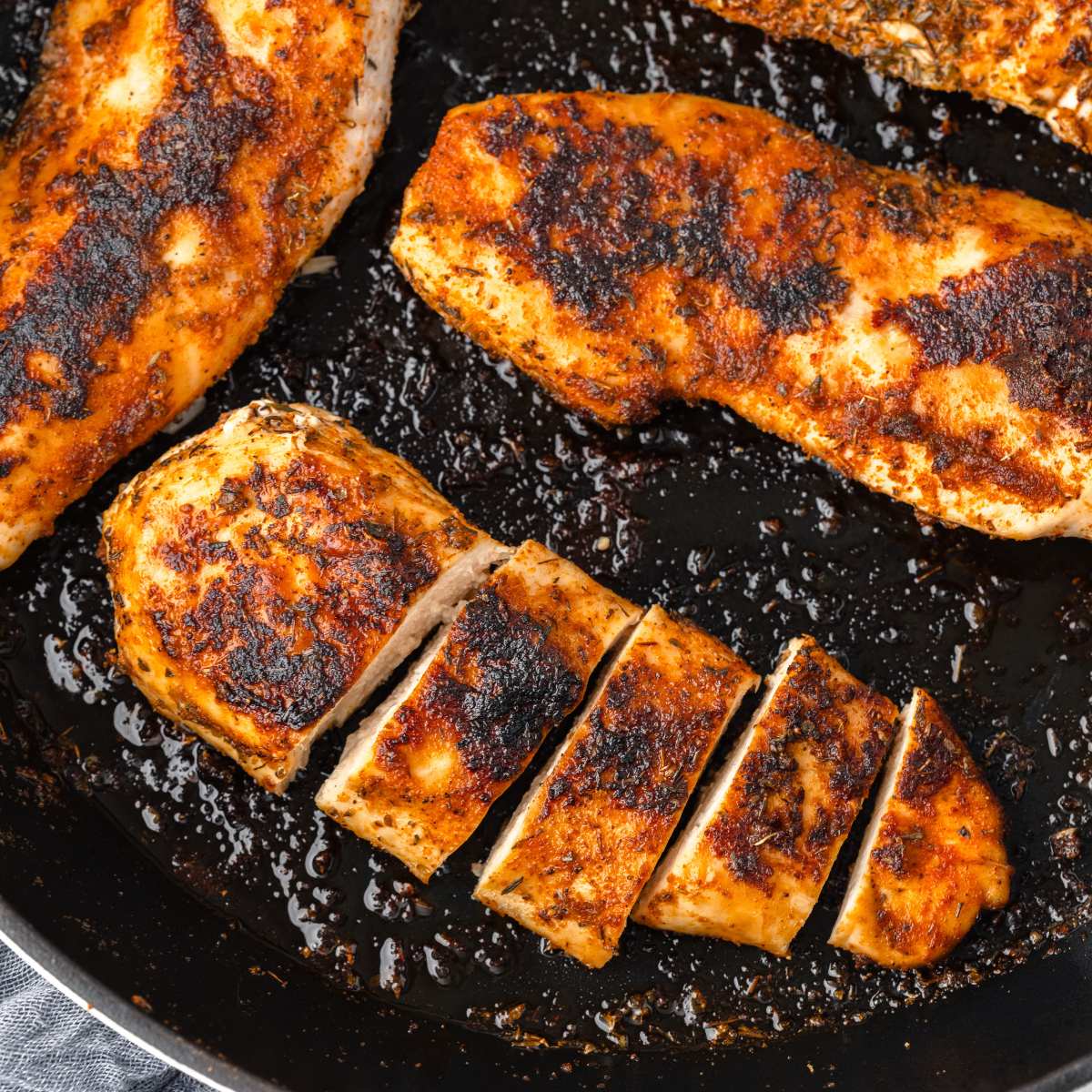 close up view of chicken breast in skillet.