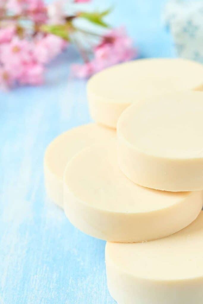 stack of cold process soap with pink flowers in background