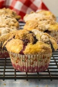finished blueberry muffins with crumb topping on wire rack.