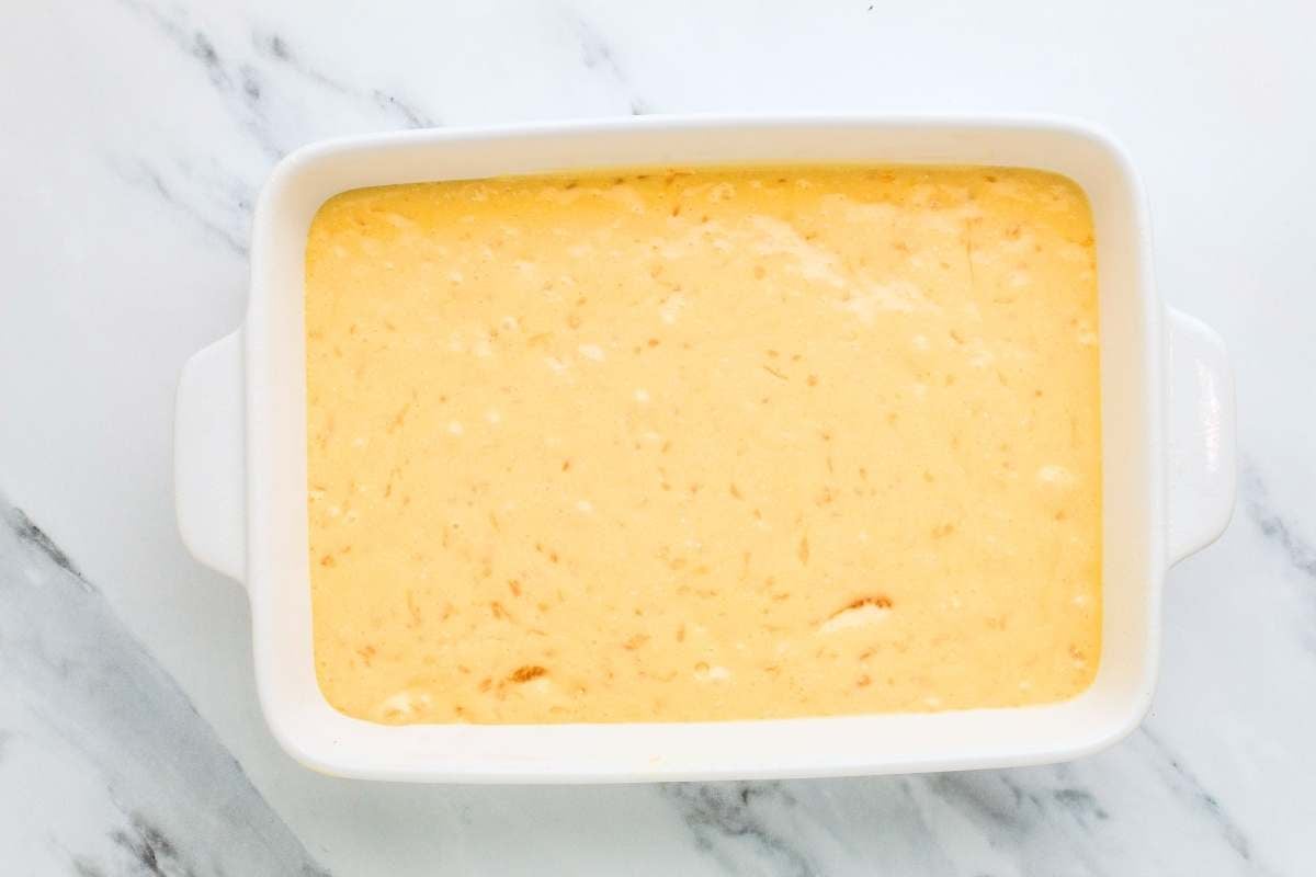 Unbaked mandarin orange cake batter in a white baking dish.
