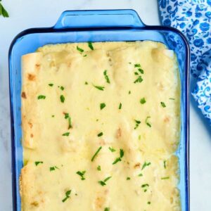 blue glass baking dish filled with white enchiladas
