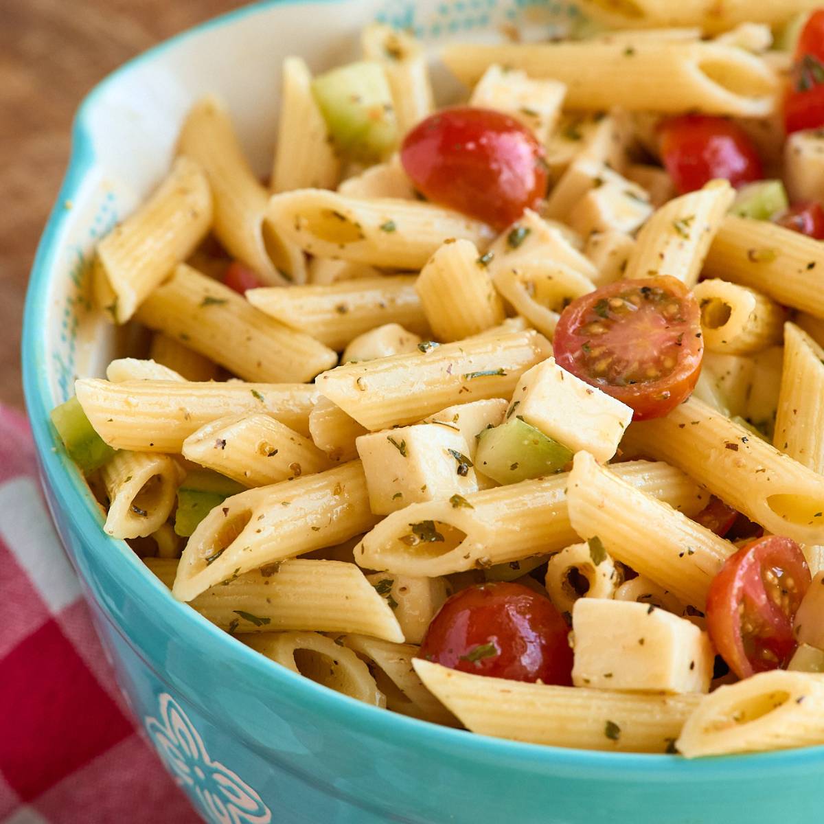 bowl of pasta salad with diced veggies and chunks of mozzarella.