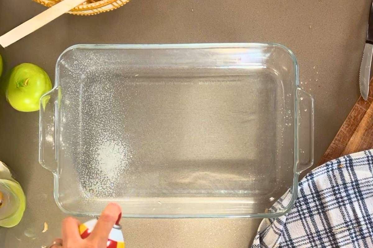 pan being sprayed with cooking spray.