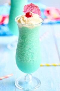 close up view of blue pina colada with pink umbrella