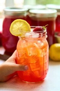 glass of diluted lemonade with lemon slice and strawberry