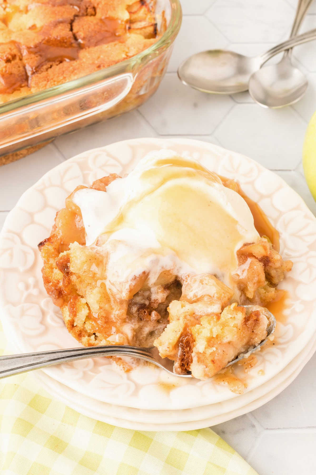 plate of caramel apple cobbler topped with ice cream.