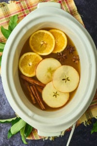 slow cooker with apple slices and whole spices.