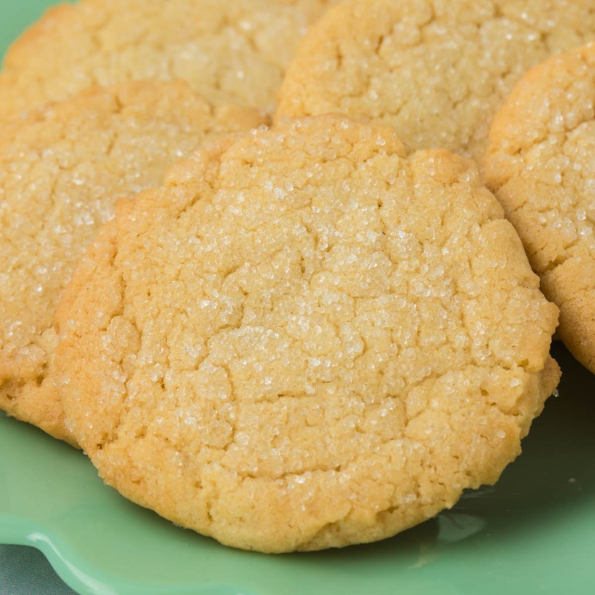 close up of sugar cookies on green plate.