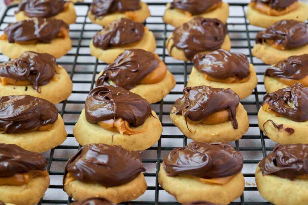 many small round cookies on wire rack.