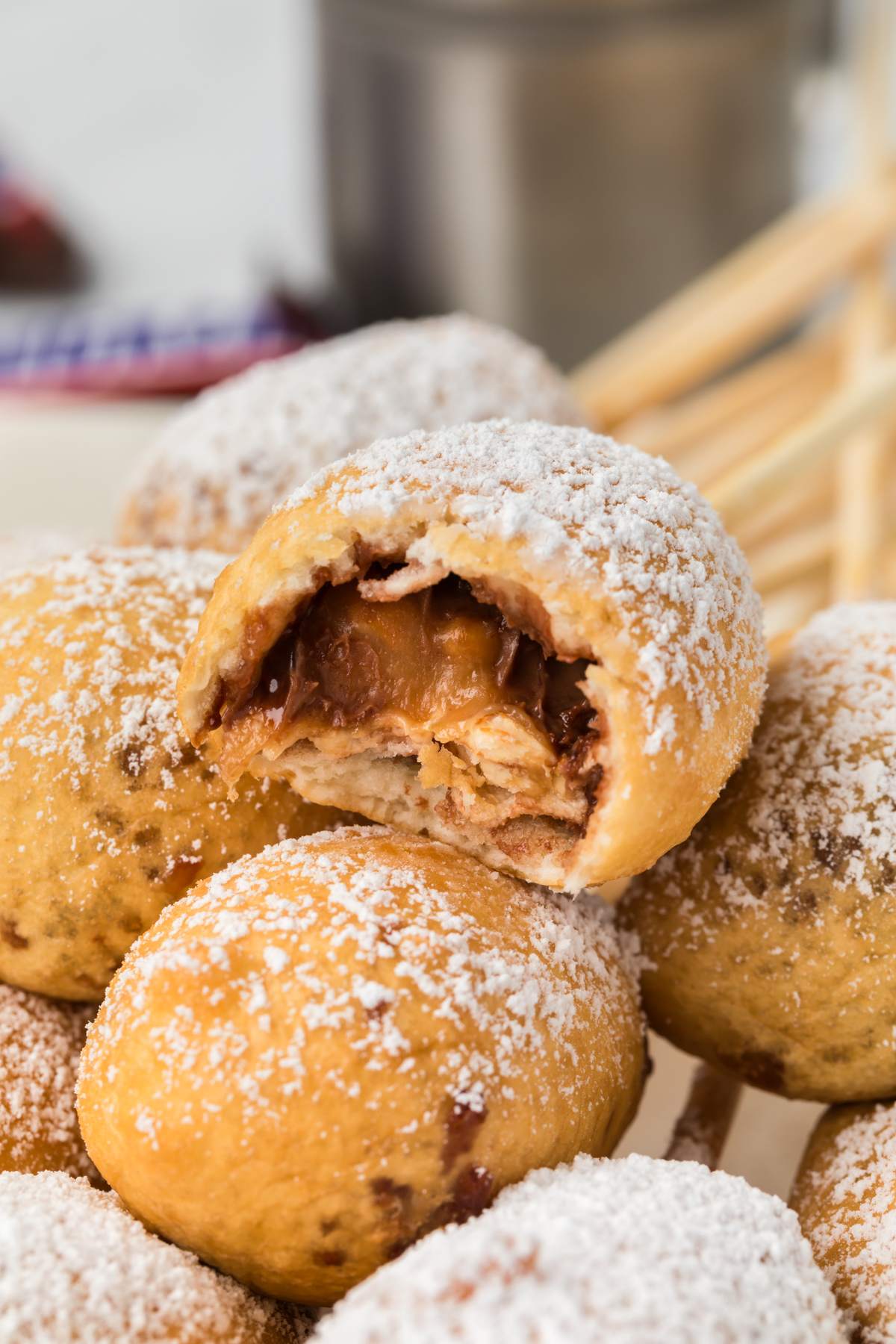 pile of deep fried snickers on plate with bite missing from one.