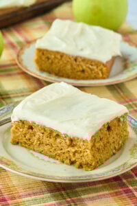 2 squares of pumpkin cake with cream cheese frosting.