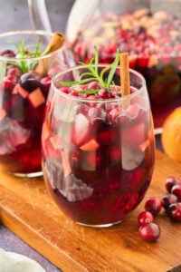 2 glasses of red sangria with rosemary and cinnamon stick.