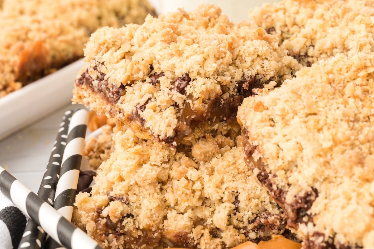 oatmeal caramelita bars on plate next to black and white straws.