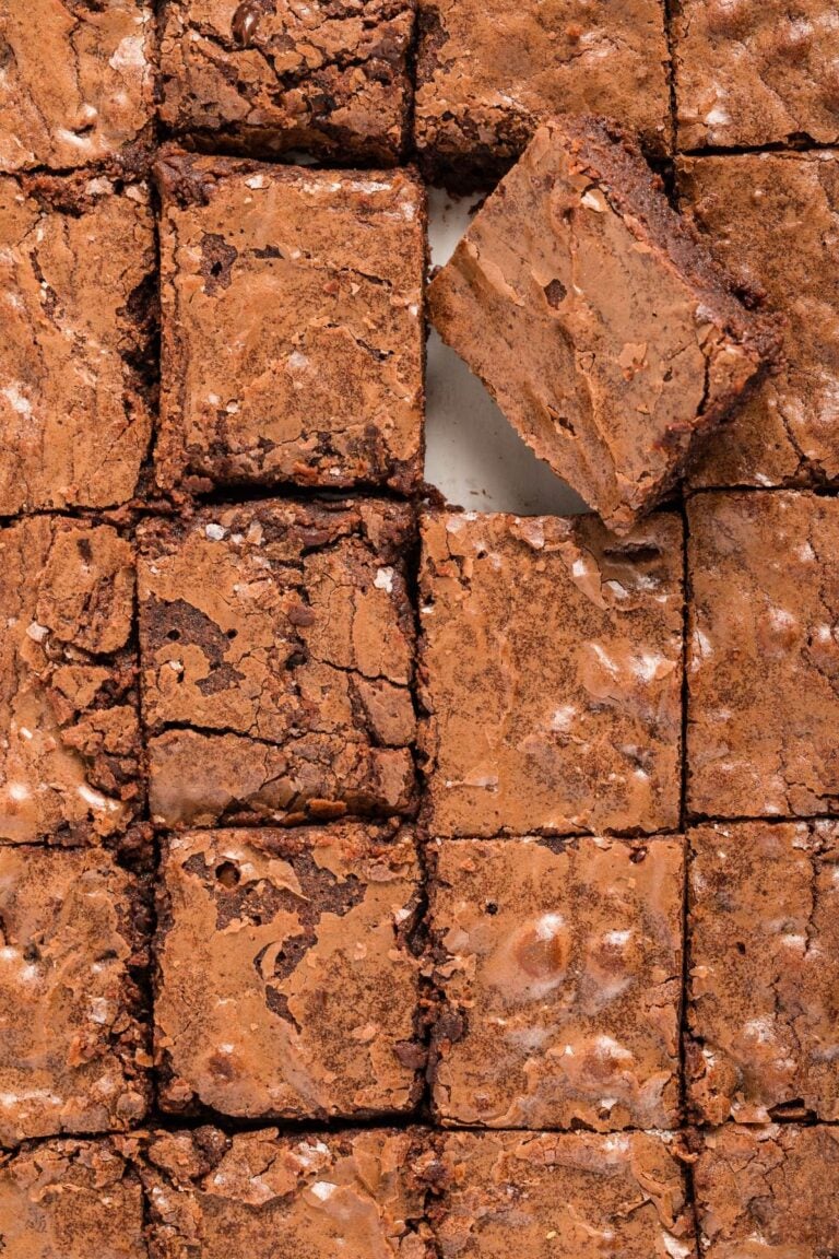 Close-up top-down view of sliced brownies with a crackly top.