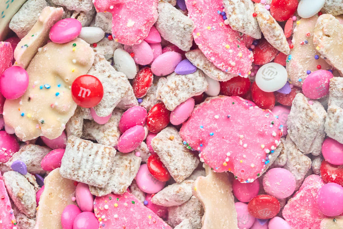 close up view of mudddy buddies with animal crackers and red and pink candies.