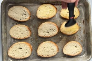 brushing sliced bread with olive oil.