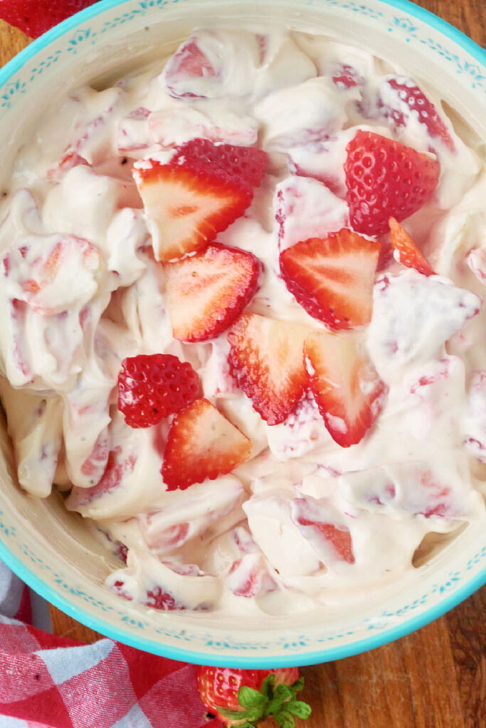 blue bowl filled with cream cheese strrawberry salad.