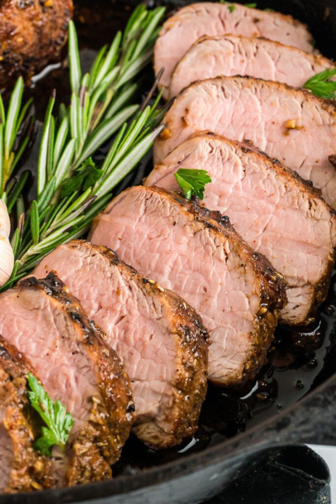 close up of sliced pork tenderloin in skillet.