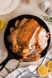 counter top with whole chicken in skillet.