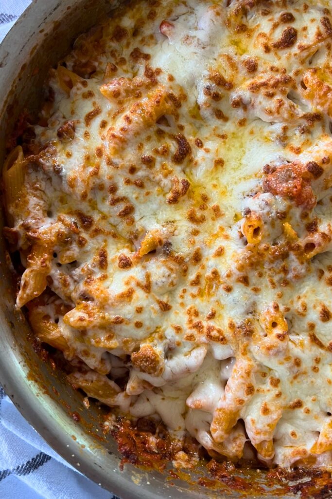 skillet with penne pasta, tomato sauce, and cheese.