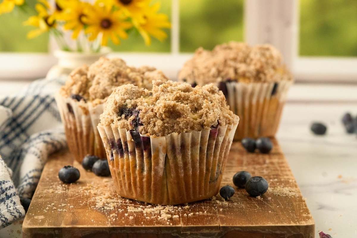 3 finished muffins surrounded by fresh blueberries