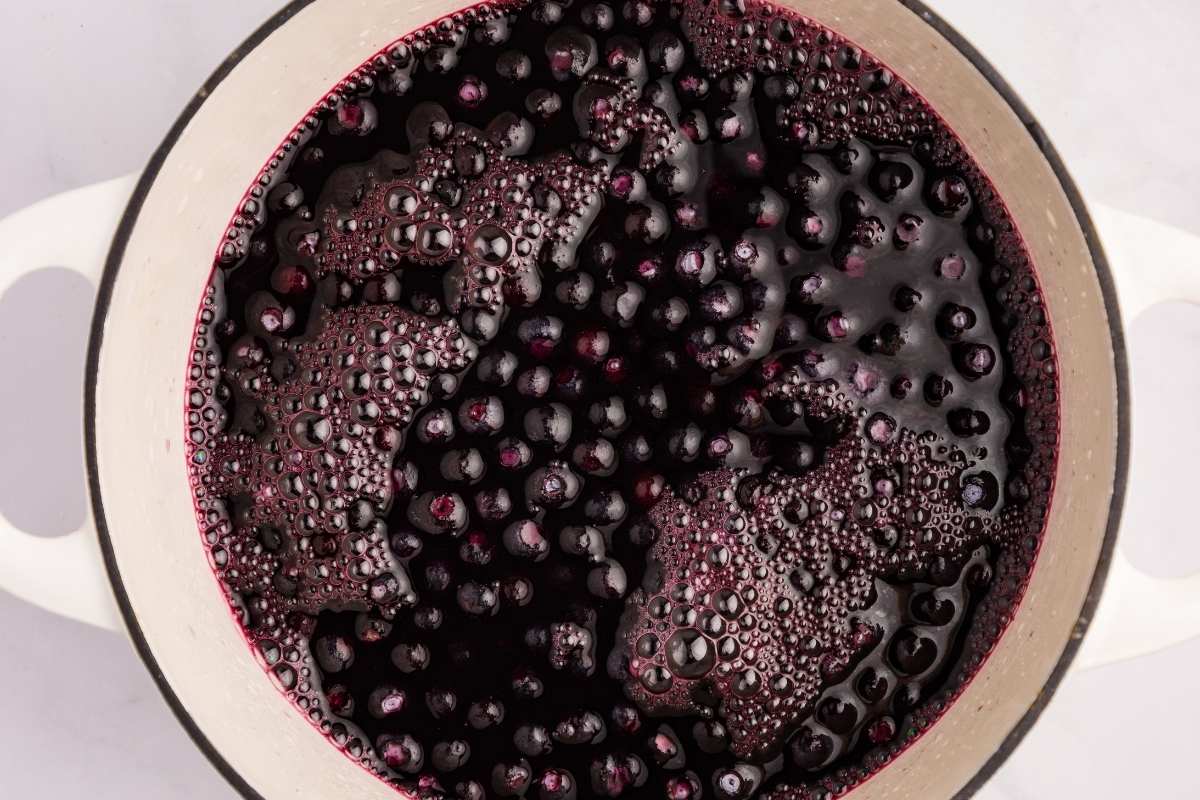 Blueberries boiling in a pot of water.