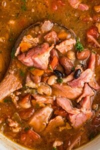 close view of soup in crock pot with ham hocks and beans.