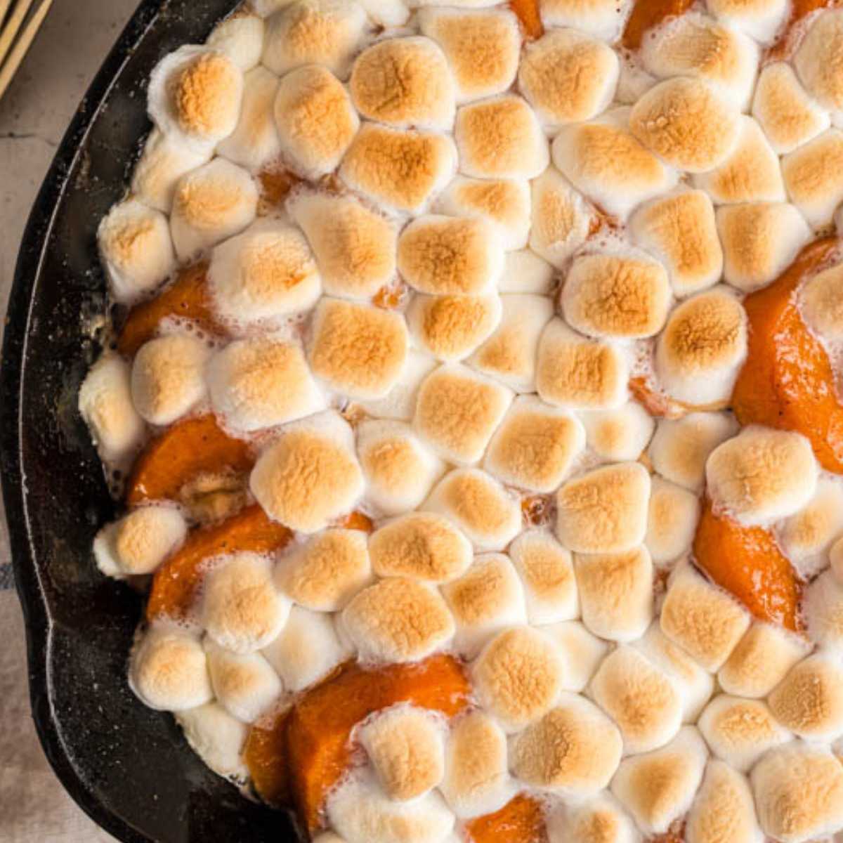 close up of sweet potato casserole with browned marshmallows on top.