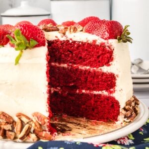 finished red velvet layer cake with strawberries on top.