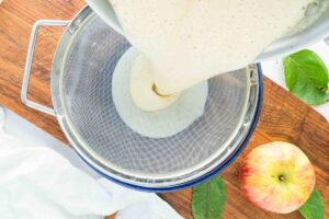 straining ice cream custard into small bowl.