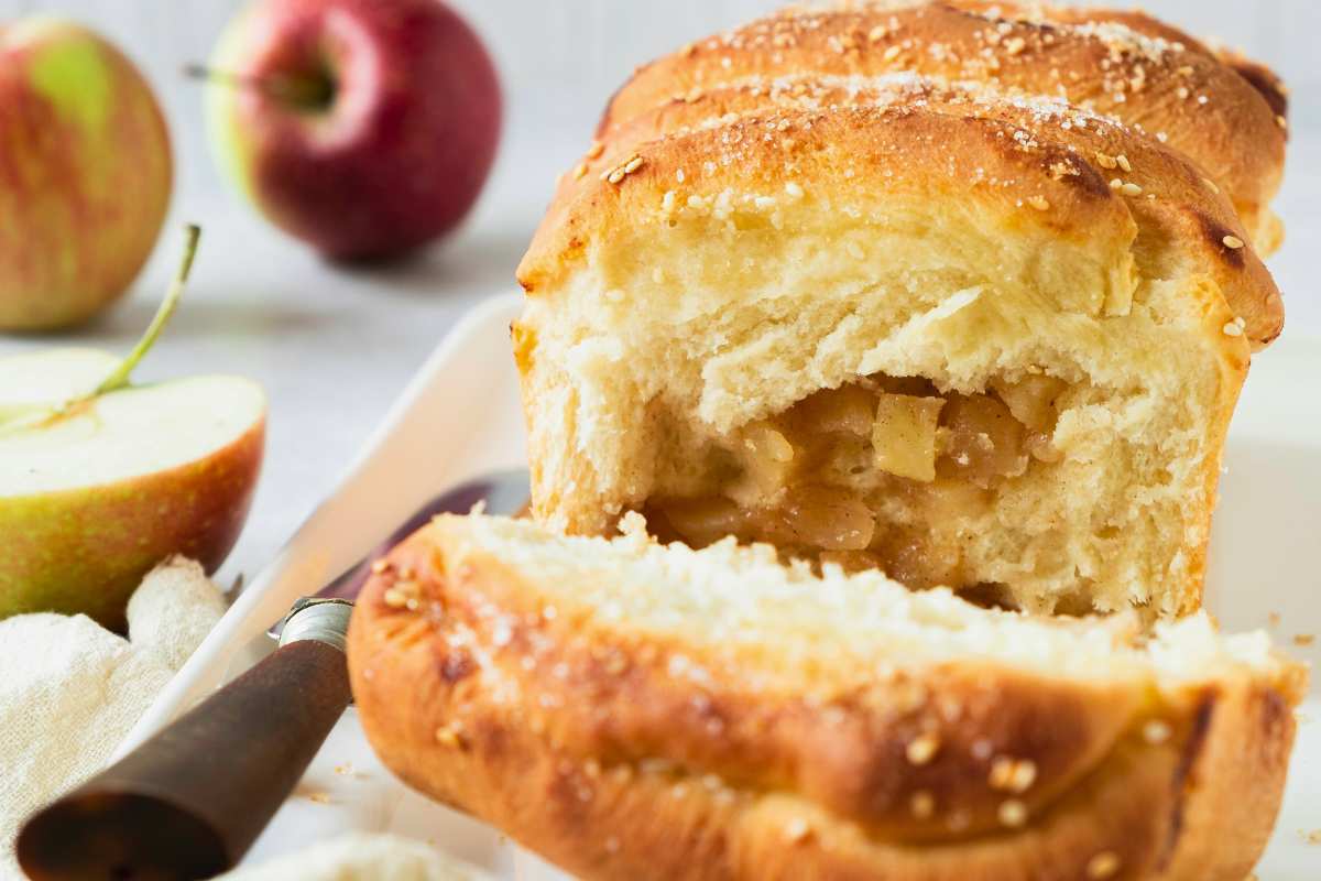 front view of apple pie bread with end sliced open to reveal apple filling inside.