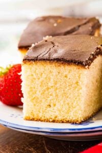 farmer's daughter cake on plate next to strawberry.