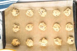 small balls of cookie dough on parchment paper.