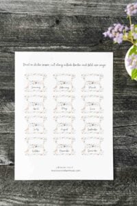 page of printable monthly tabs laid out on wooden surface.
