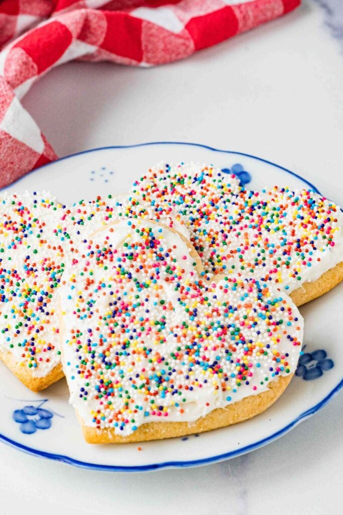 stack of frosted cookies with sprinkles.