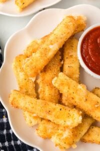 platter of deep fried mozzarella sticks and marinara sauce.