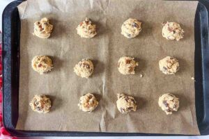 scoops of cookie dough on parchment lined baking sheet