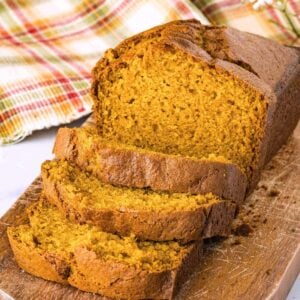 sliced loaf of pumpkin bread on wooden board.
