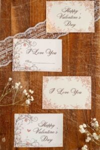 four vintage looking valentines cut and printed on lacy and floral surface.