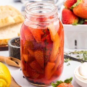 jar of pickled strawberries on kitchen counter.