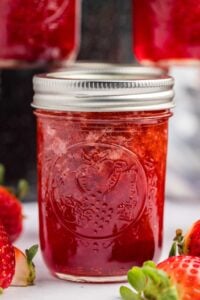 a close-up of a single jar of strawberry preserves.