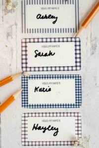 printed name tags on white wood surface.
