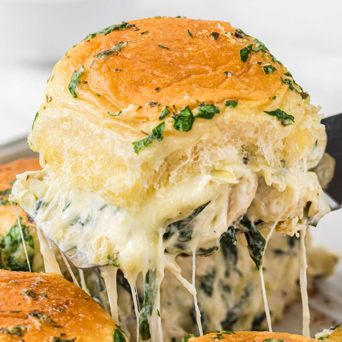 cheesy slider lifted out of pan.