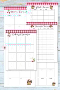 strawberry planner printables laid out on blue wooden surface.