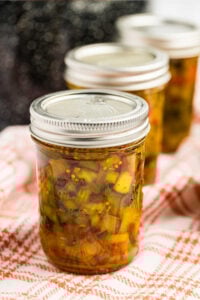 sealed jars of sweet relish on red checkered cloth.