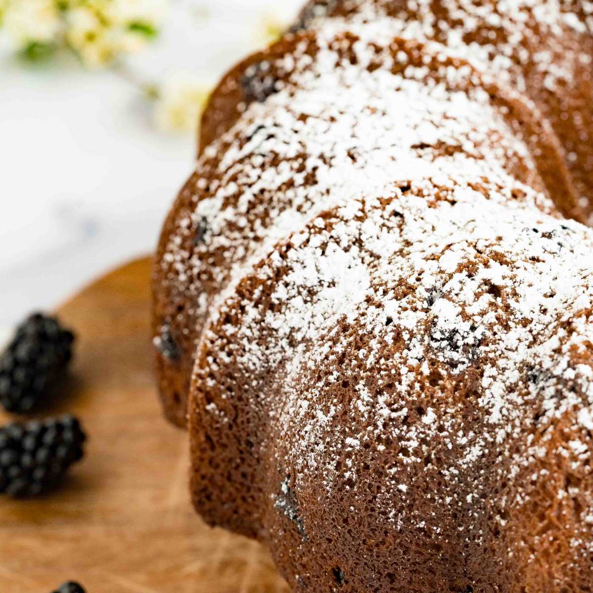 close-up of a blackberry Bundt cake with a dusting of powdered sugar.