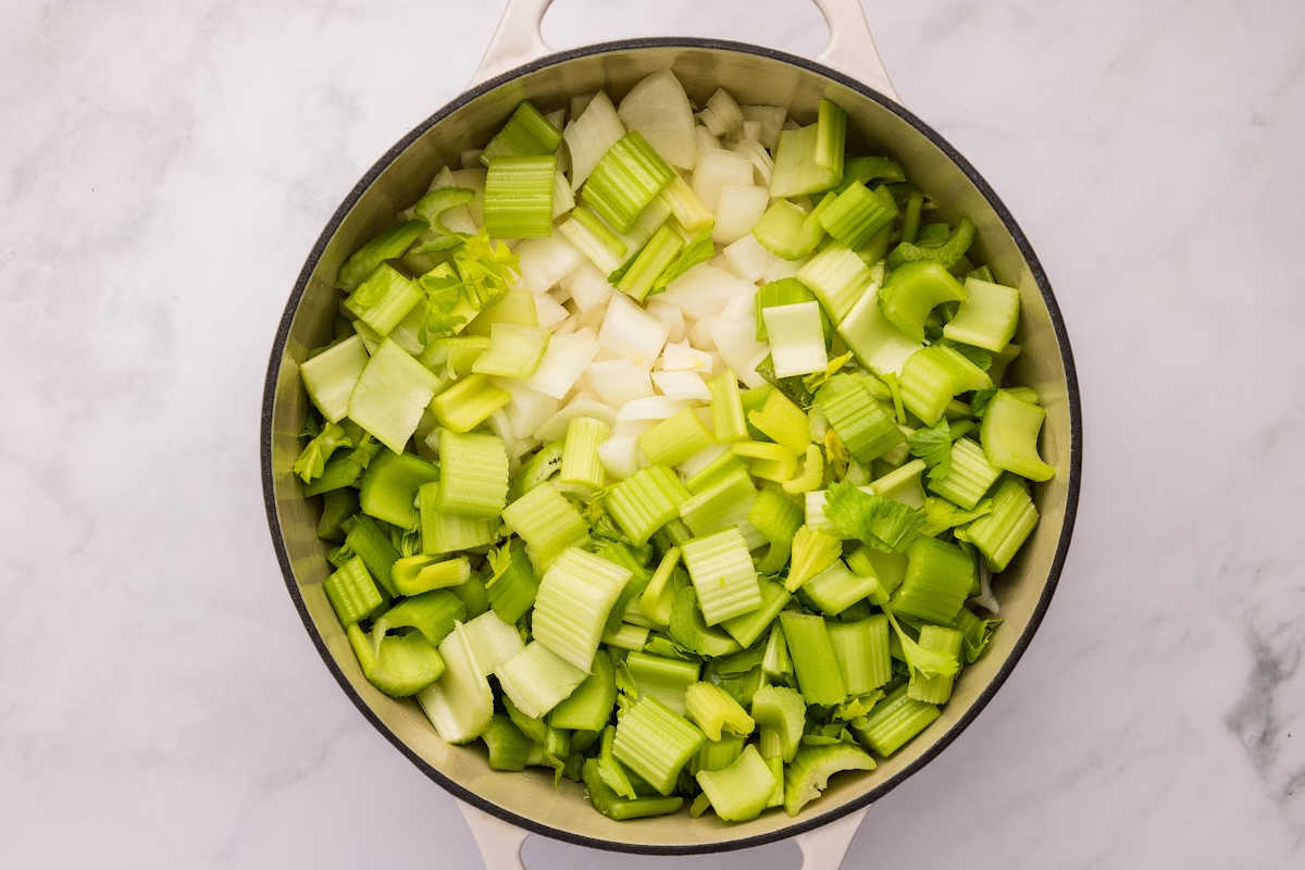 Chopped onions and celery in a large pot, ready for cooking.