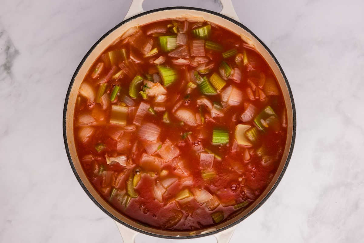 The pot now includes cut tomatoes, mixed with the celery and onions, starting the soup process.