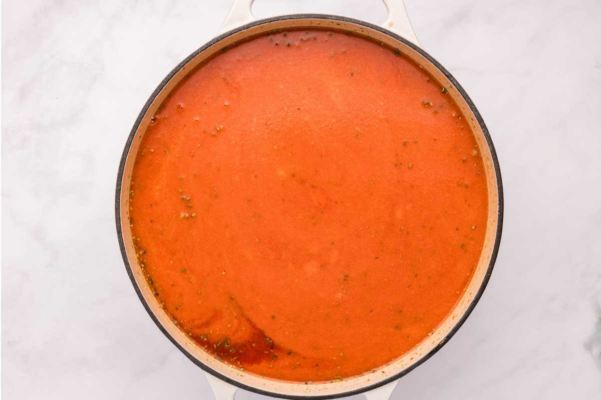 The cooking pot showing the tomato soup after being blended into a smooth texture.