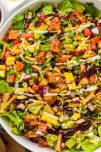 close up of bbq chicken salad all mixed with dressing on top.